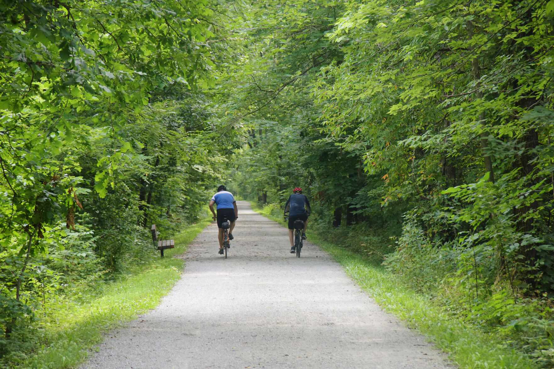 Two men bike on the MKT trail